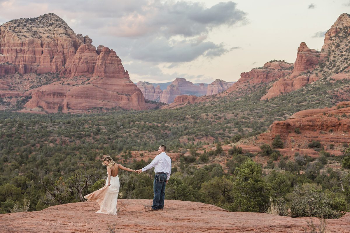 Bride holds her grooms hand with the red rock vista in the backdrop at Bell Rock