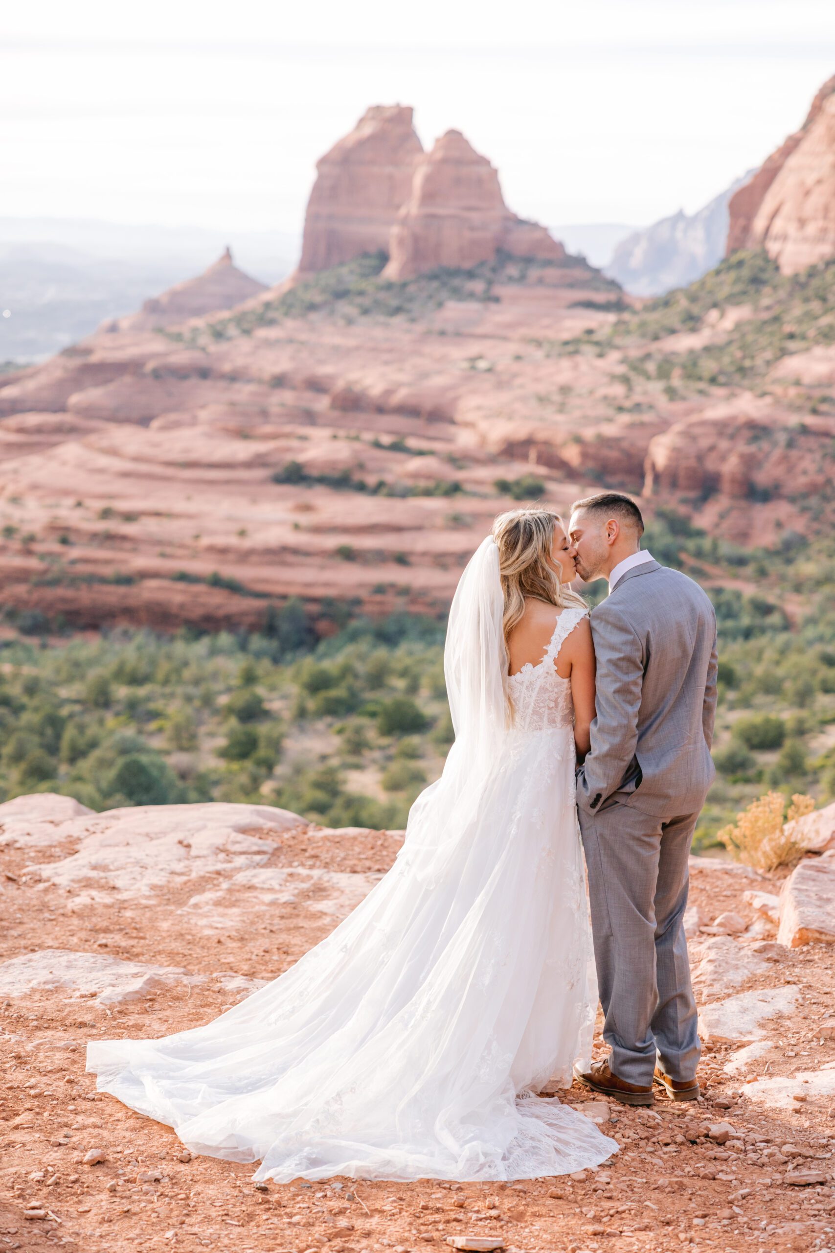 Sedona elopement photographer. Bride and Groom kiss on the edge of Merry Go Round.