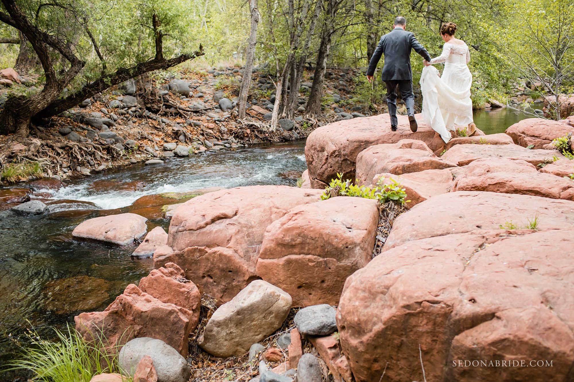 A couple walking on the red rocks at Serenity Point at L'Auberge