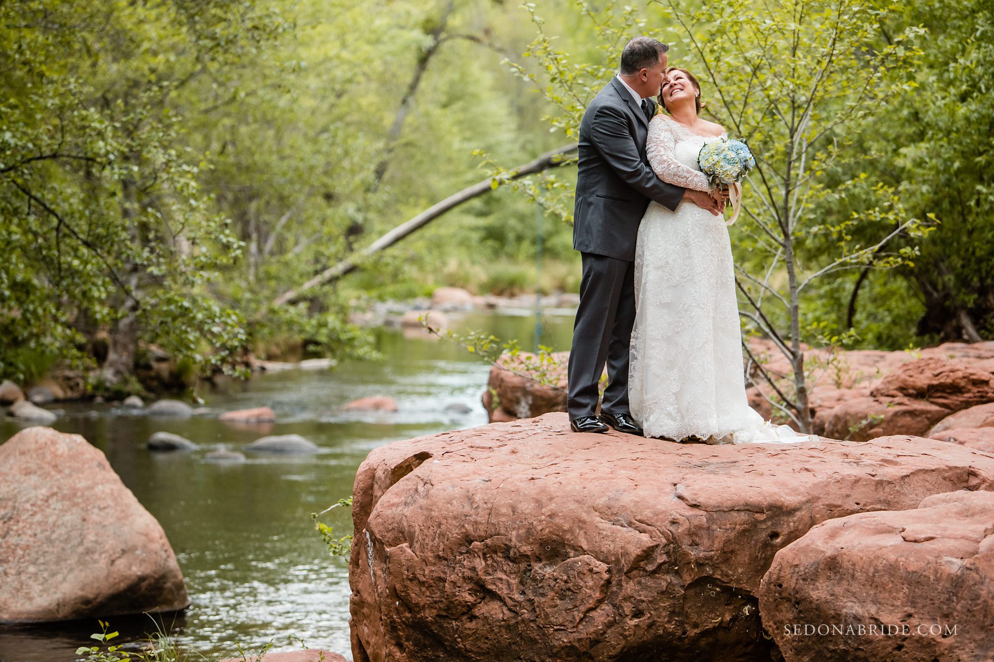 A couple standing on the red rocks on Serenity Point 