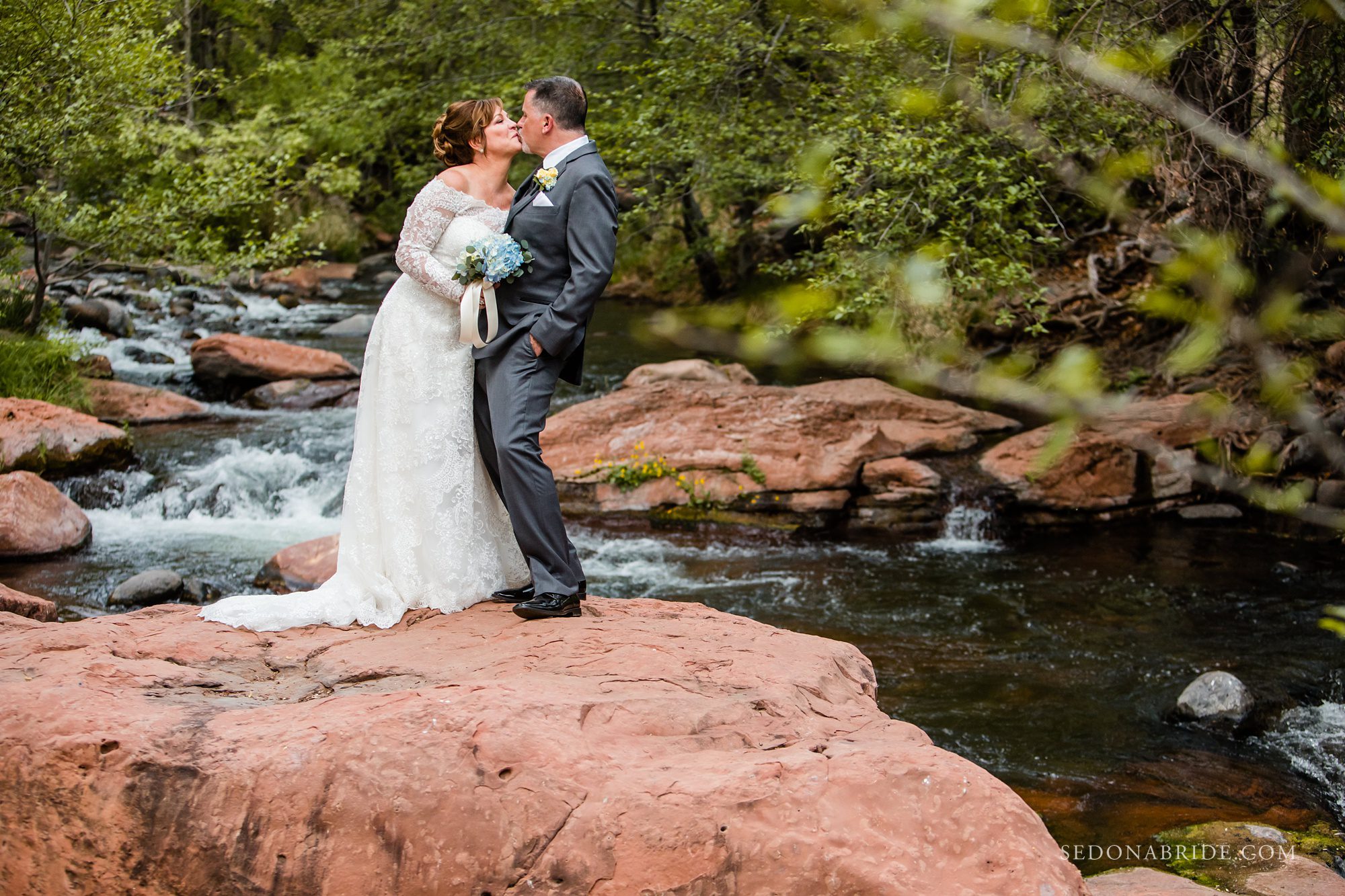 A bride and groom kissing on Oak Creek at Serenity Point 