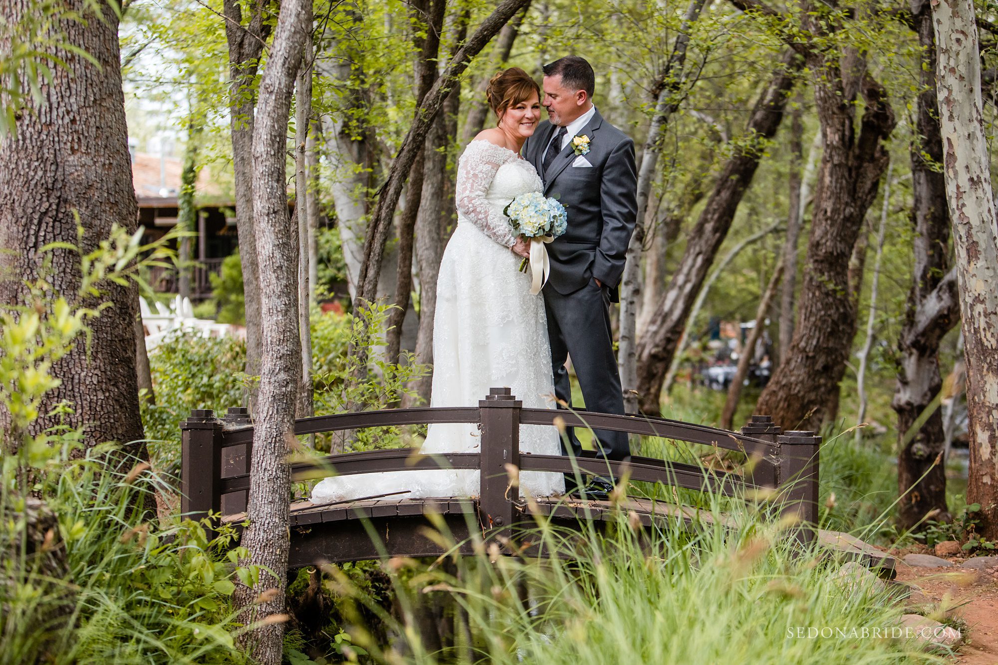 Bride and groom standing on a bridge at L'Auberge 