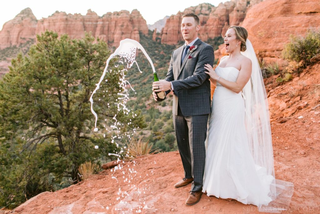 Champagne pop during an elopement in Sedona at Merry Go Round rock