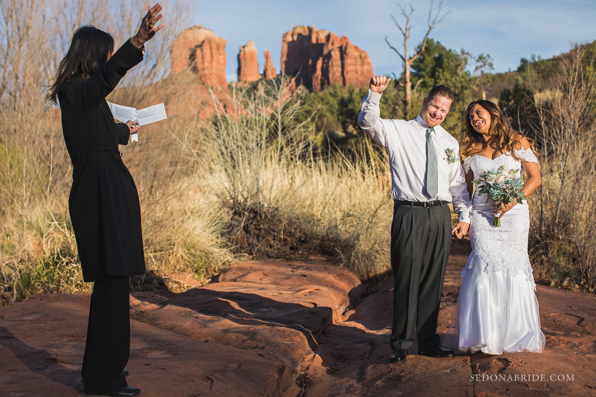 Couple raises their hands with excitement during their Red Rock Crossing Sedona wedding