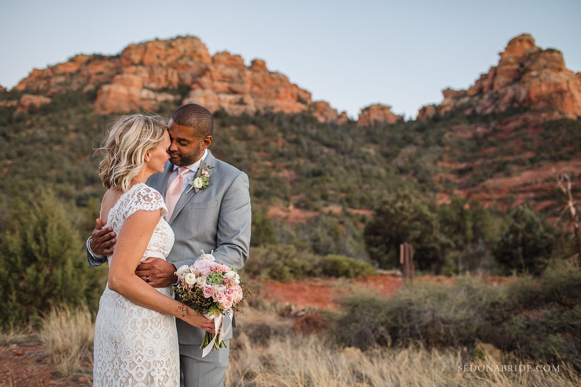 Sedona wedding photo of a couple holding each other at the bottom of Schnebly Hill