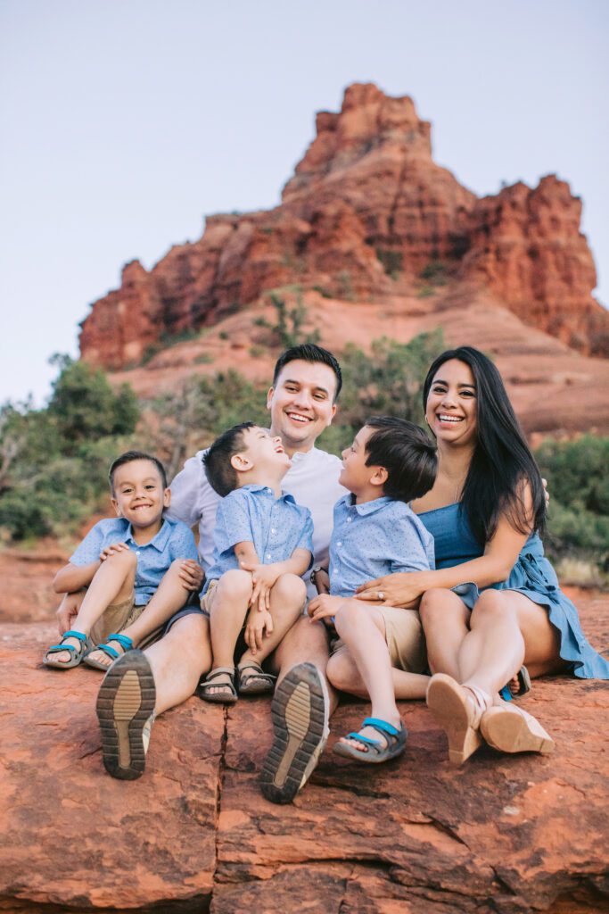A young family sits for a family photo in Sedona.